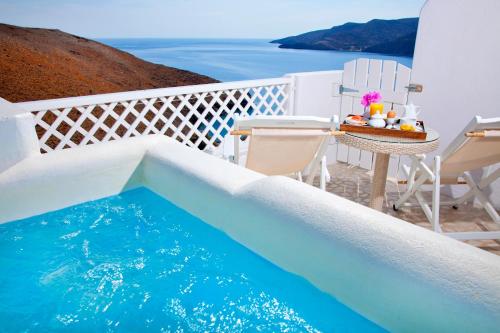 a pool on a balcony with a table and chairs at Tholaria Boutique Hotel in Astypalaia Town