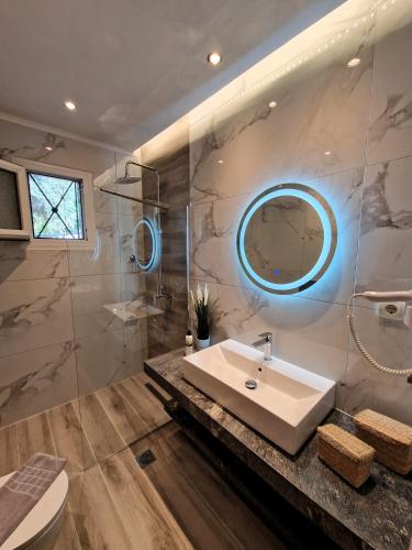 a bathroom with a sink and a mirror at Villa Ftelia Oasis,Skiathos in Megali Ammos