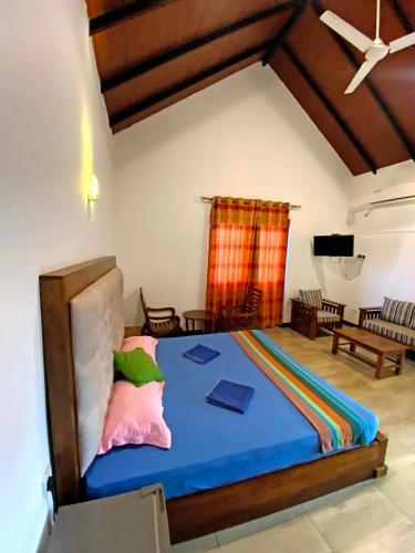 a bedroom with a bed and a living room at Hotel Vish Ceylon in Talawatugoda