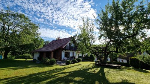 a house with a tree in the front yard at Dům Amelia s vyhřívaným bazénem in Miřetice