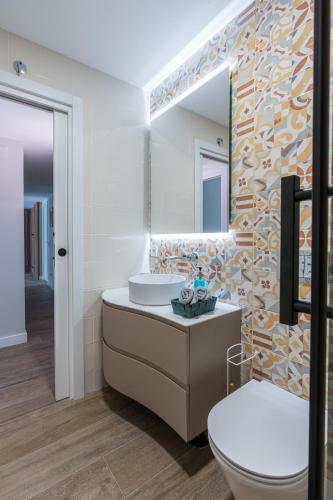 a bathroom with a sink and a toilet and a mirror at Acogedor Refugio con Terraza in Alcalá de Henares