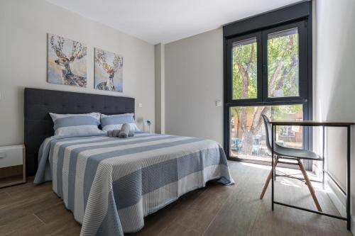 a bedroom with a bed and a chair and a window at Acogedor Refugio con Terraza in Alcalá de Henares