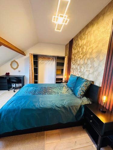 - une chambre avec un lit bleu et un bureau dans l'établissement Jabeen's House Bedroom 1, à Bezons