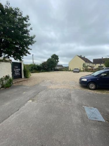 a parking lot with a car parked in a driveway at The Ilchester Arms Hotel, Ilchester Somerset in Ilchester