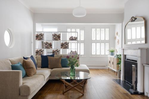 a living room with a couch and a table at Luxury Family Home in Central Windsor with Large Garden, Games Room, Office, Parking & Pet-Friendly in Windsor