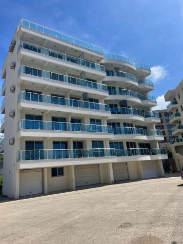 a large white apartment building with two garage at SunSide Apartment Naila - Dobra Voda in Dobra Voda