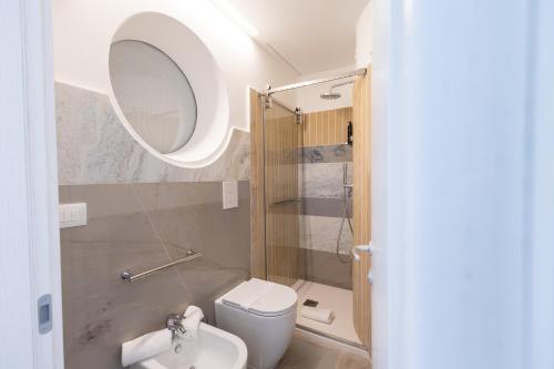 a bathroom with a toilet and a sink and a mirror at Maggiano Boutique Hotel in Peschici