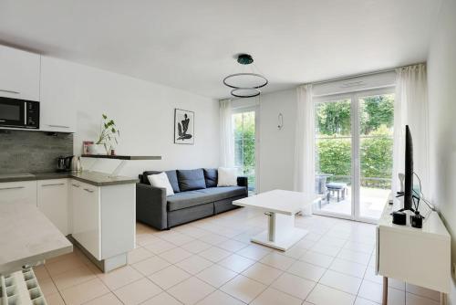 un salon blanc avec un canapé et une table dans l'établissement Le 17 - Super logement Proche Disney - Jardin, à Torcy