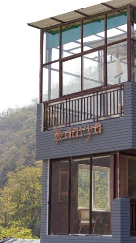 a building with a sign on the side of it at Aavya Wellness Retreat Center in Rishīkesh