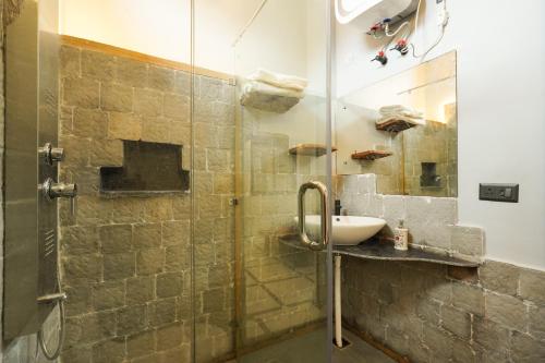a bathroom with a sink and a glass shower at Aavya Wellness Retreat Center in Rishīkesh