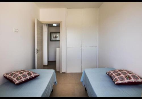 2 letti in una camera con 2 cuscini sopra di Casa Relax Torre Pali a Torre Pali