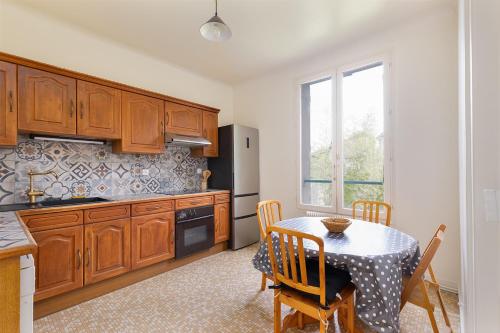 une cuisine avec des placards en bois et une table avec une salle à manger dans l'établissement Cozy house with garage & large garden, PARIS Center 30min RER A, Orly airport, à Limeil-Brévannes