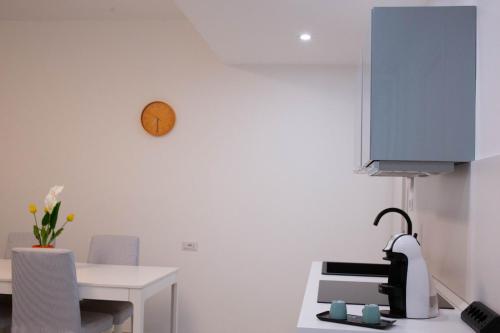 a kitchen with a table and a clock on the wall at La casa di mest Pepp in Monopoli