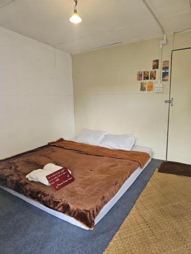 a bedroom with a large bed with a book on it at Panakluea at Kokuang Homestay in Ban Na Lae