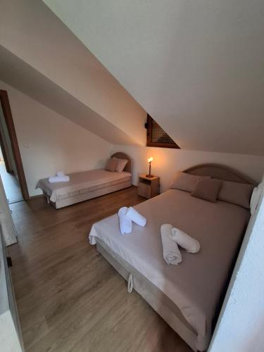 a bedroom with two beds with white towels on them at Chalet LENA & One Bedroom Apartment Lena in Žabljak