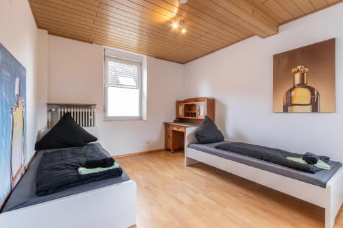a bedroom with two beds and a wooden ceiling at Wohnung für 8 Personen in ehemaligem Weingut mit 4 Schlafzimmern in Rommersheim