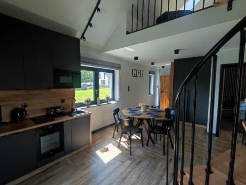 WojcieszyceにあるDomki Karkonosze Pod Dębemのテーブルと椅子のあるキッチンとダイニングルーム