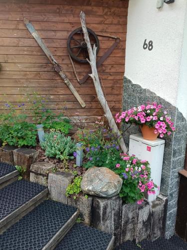 a garden with flowers and plants on a wall at Haus Bergwind in Sankt Leonhard im Pitztal