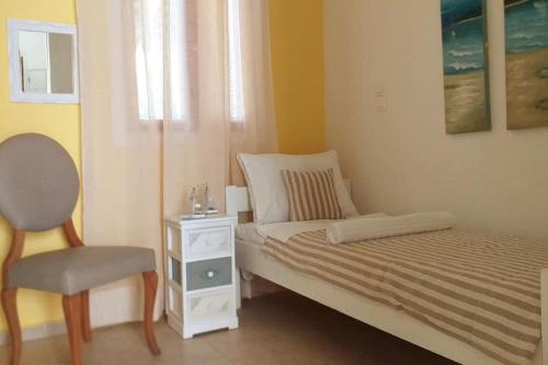 a small bedroom with a bed and a chair at Amalia House Kalamaki in Kalamaki Heraklion
