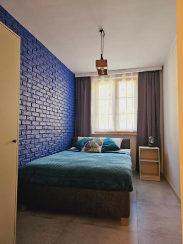 ein Schlafzimmer mit einem Bett und einer Ziegelwand in der Unterkunft Kryształ A10, Garaż in Karpacz