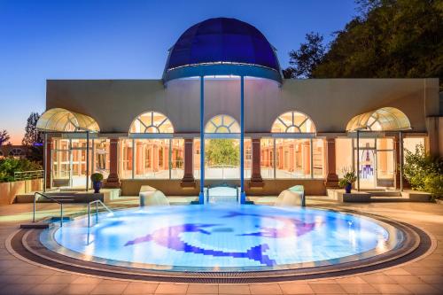 a large swimming pool in front of a building at LES TERRASSES DE BORDA*** in Dax