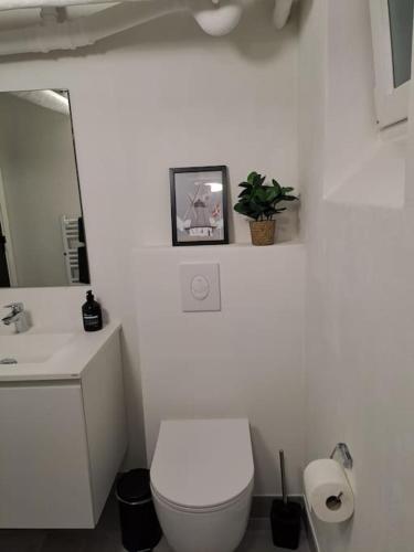 a white bathroom with a toilet and a sink at Centralt beliggende hyggeligt byhus med 8 sovepladser 130m2 med pejs in Holstebro