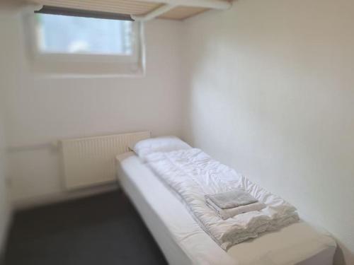 a white couch in a room with a window at Centralt beliggende hyggeligt byhus med 8 sovepladser 130m2 med pejs in Holstebro