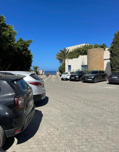 a group of parked cars parked in a parking lot at Appartement bord de mer in Jbila