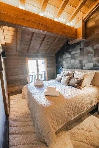 une chambre avec un grand lit avec deux serviettes dessus dans l'établissement Appartement aux pieds des pistes, à Saint-Étienne-de-Tinée