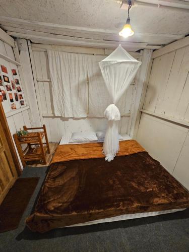 a small room with a bed with a white umbrella at Panakluea at Kokuang Homestay in Ban Na Lae