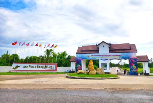 a building with a sign in front of it with flags at MonMonBoutique Hotel in Thakho