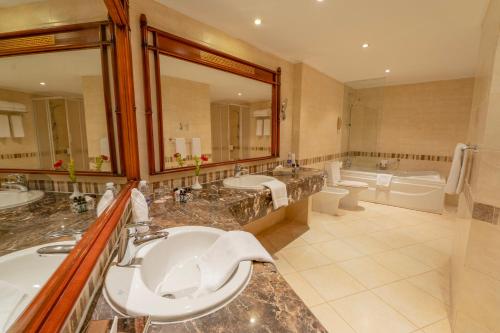 a bathroom with two sinks and a large mirror at Jolie Ville Hotel & Spa Kings Island Luxor in Luxor