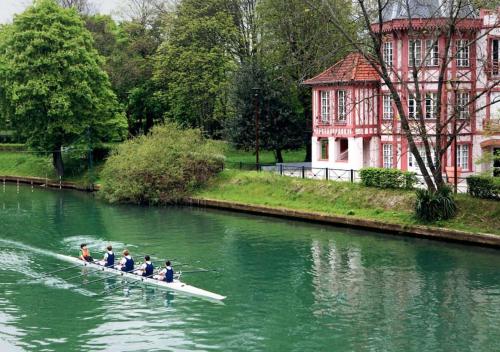 a group of people in a boat on a river at Le petit moret in Joinville-le-Pont