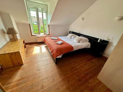 une chambre avec un grand lit avec une couverture rouge dans l'établissement L'Authentique - maison avec jardin - 4 personnes, au Mans