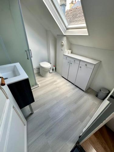 La salle de bains est pourvue de toilettes, d'un lavabo et d'une lucarne. dans l'établissement L'Authentique - maison avec jardin - 4 personnes, au Mans