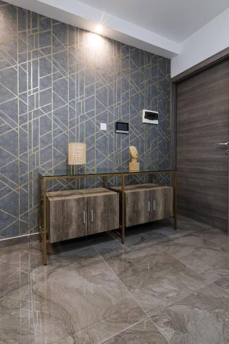 a bathroom with two sinks and a tiled wall at DuplexPenthouse seafront with hot tub by Homely in St. Paul's Bay