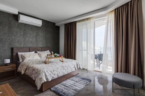 a bedroom with a bed and a large window at DuplexPenthouse seafront with hot tub by Homely in St. Paul's Bay