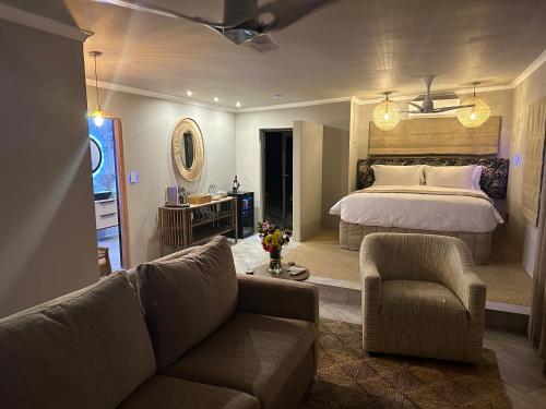 a living room with a bed and a couch at Oase by 7 Star Lodges - Greater Kruger Private 530ha Reserve in Hoedspruit