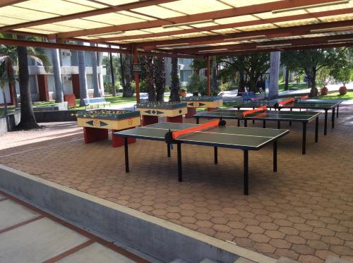 a row of ping pong tables sitting under a building at Hotel Y Parque Acuático La Caldera in Abasolo