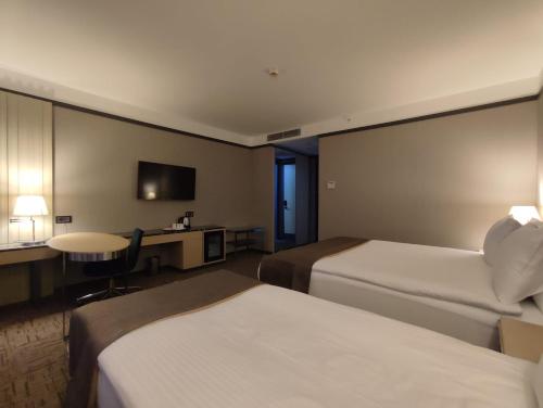 a hotel room with two beds and a television at Invite Hotel Corner Trabzon in Trabzon