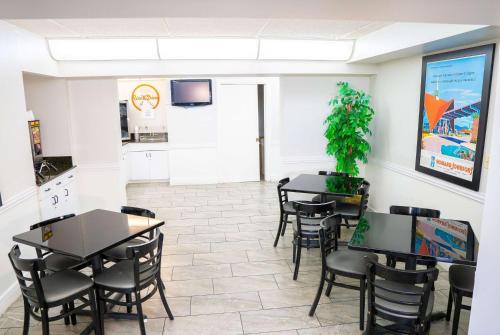 a dining room with tables and chairs and a kitchen at Howard Johnson by Wyndham Clearwater - Dunedin in Clearwater