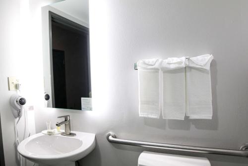 a bathroom with a sink and a toilet and towels at Microtel Inn & Suites by Wyndham Charlotte/Northlake in Charlotte