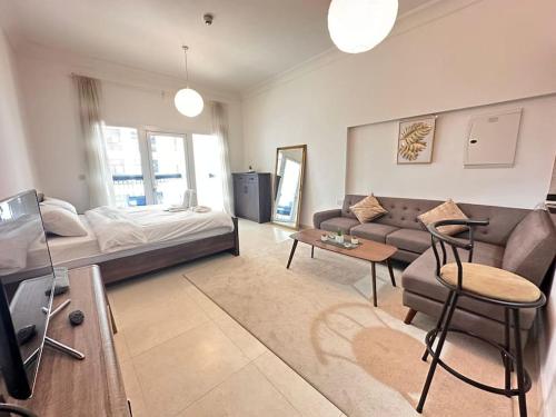 a living room with a bed and a couch at NA HARF108 Stylish Studio - YAS Island in Abu Dhabi