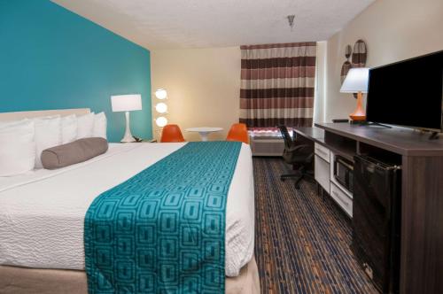 a hotel room with a bed and a flat screen tv at Howard Johnson by Wyndham Scott Lafayette in Scott