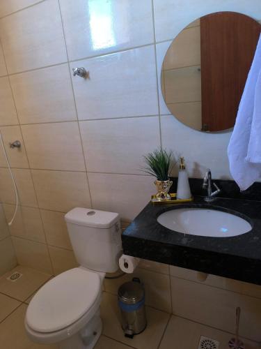 a bathroom with a toilet and a sink and a mirror at Apartamento completo in Montes Claros