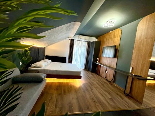 a bedroom with a bed and a couch in a room at Prestige House Delux in Curtea de Argeş