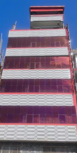 a tall building with red and white tiles on it at RAJHAT MARANAO House in Bodh Gaya