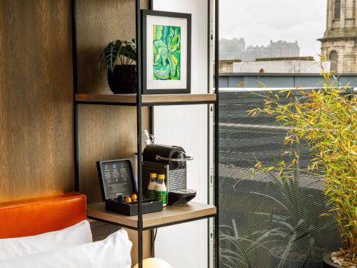 a room with a phone on a shelf next to a window at ibis Styles Edinburgh St Andrew Square in Edinburgh