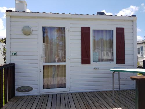 a house with a window on a deck at Bungalows Land'shause in Pataias