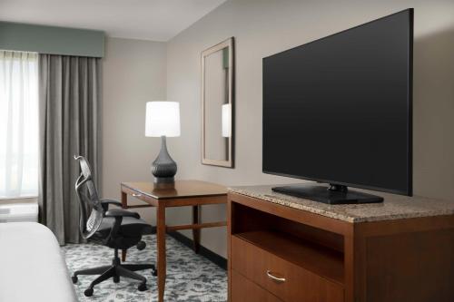 a hotel room with a flat screen tv on a desk at Hilton Garden Inn Hoffman Estates in Hoffman Estates